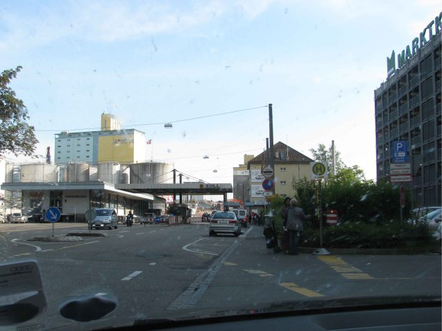You don't have to buy the motorway vignette to drive in Switzerland. Even the major motorway border points have backstreet detours. If you get caught in the vignette queue, in our experience border staff are happy to direct you. Photo: The Swiss suburban border point at Basel, May 2012. Now unused since Switzerland joined the Schengen Area.