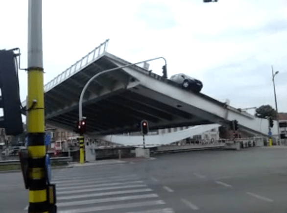 Your worst nightmare. Not just caught on a drawbridge as it lifts up, but the front wheels are hanging over the edge, you are in a foreign country and everybody waiting in the traffic opposite has a smartphone/video camera. The driver of a French-registered Toyota RAV4 heading into Bruges on the N9 from the north west apparently decided to chance it when he saw amber lights flashing on the Scheepsdalebrug. Clearly he came within moments of pulling it off. Photo, screen grab from YouTube ‘Car gets stuck on Bruges bridge’.