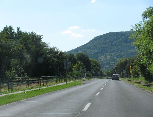 Our problem is that we can’t find anywhere to stop and take it all in. This north bank is an unbroken chain of campsites, restaurants, trees and/or fences. Next time we’ll check out the southern shore – there’s a motorway for a start for faster progress, just up and away from the shore – or take the road up into that hill which doesn’t occur to us at the time. We haven’t mentioned how hot it is, well over 37 degrees. Eventually we find a little marina on a side road but even then sit behind barbed wire chomping through the food we bought in Tesco earlier (if you didn’t know Tesco is massive in Hungary).